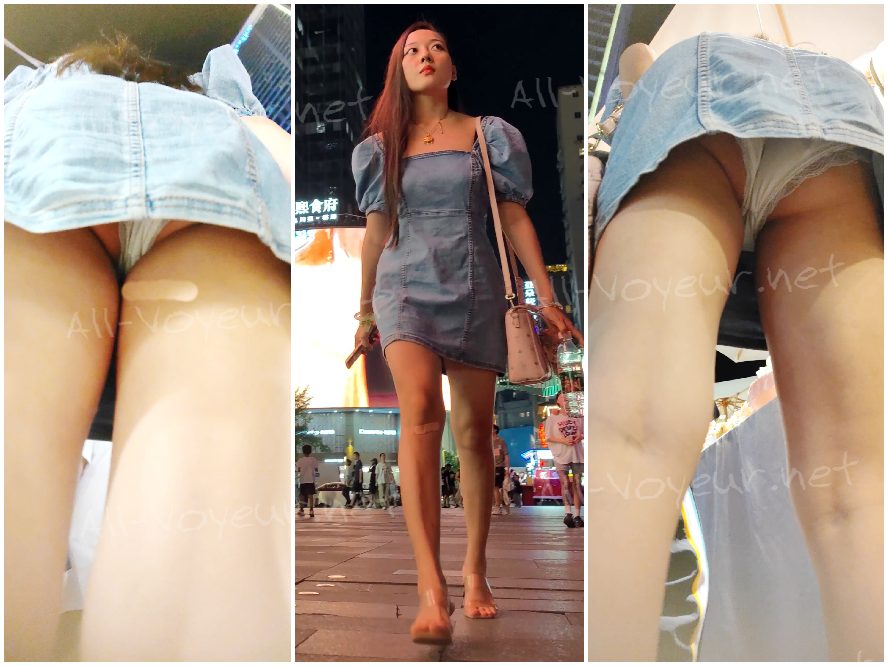 青いデニムのドレスを着た美しい女性が、ドレスの裾の白い下着を脱いで物を買うためにかがんでいる姿が映っています...