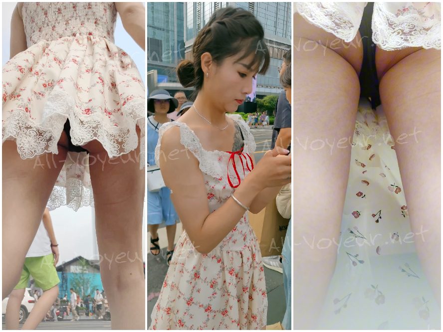 白い花柄のドレスを着た若い女性がボーイフレンドと一緒に買い物に来ています。彼女はフィットした黒のトップスを着ています。