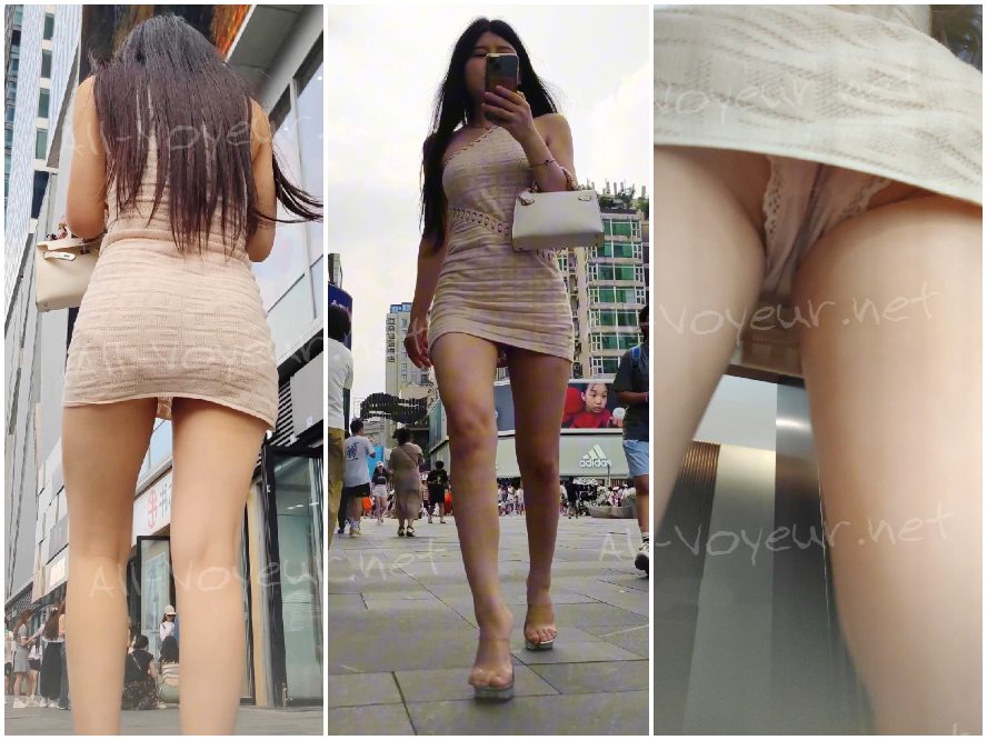 白い花柄のドレスを着た若い女性がボーイフレンドと一緒に買い物に来ています。彼女はフィットした黒のトップスを着ています。