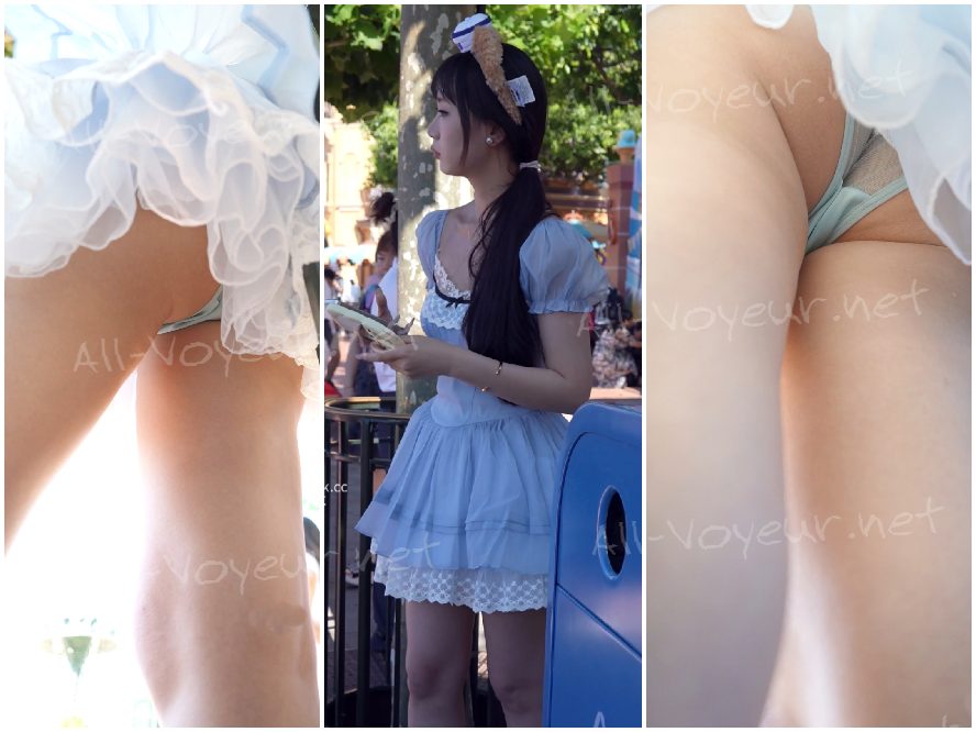 青いレースのドレスを着た若い女性がパフォーマンスを見ています...彼女は半透明のアンダーシャツを着て半分しゃがんでおり、CDをかけています。