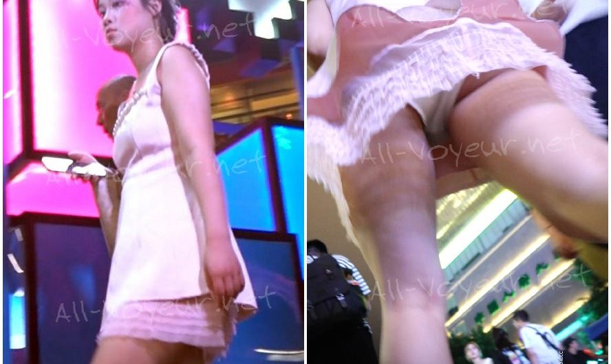 （原文：孔成）ドレスを着た可愛らしい若い女性が買い物をしている。ドレスのレースの裾から彼女の白い肌が覗いている。